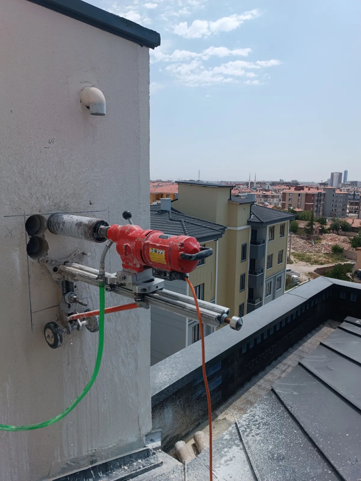 Çatı katında betonarme duvara kurulmuş karot makinesiyle yatay delik delme